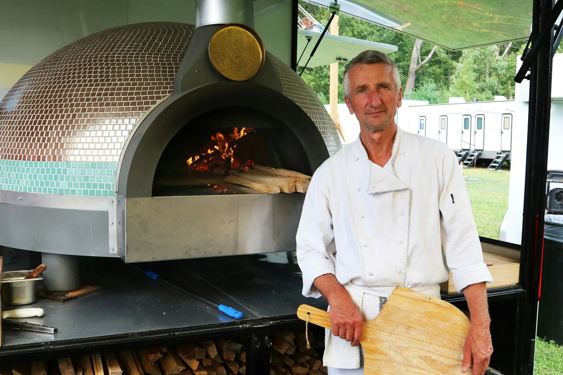 Pizzabakker naast de mobiele oven